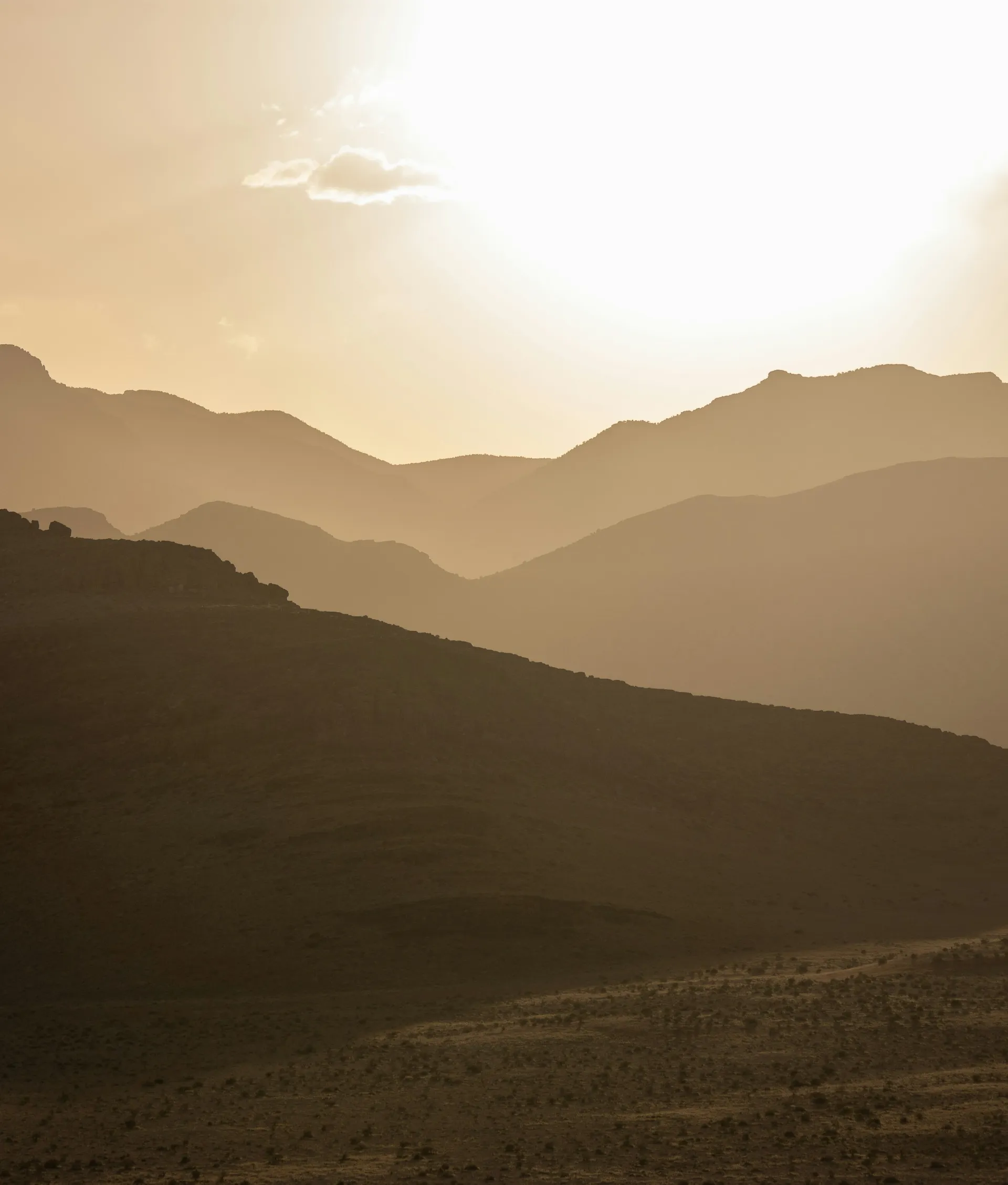 Sun setting over desert mountains